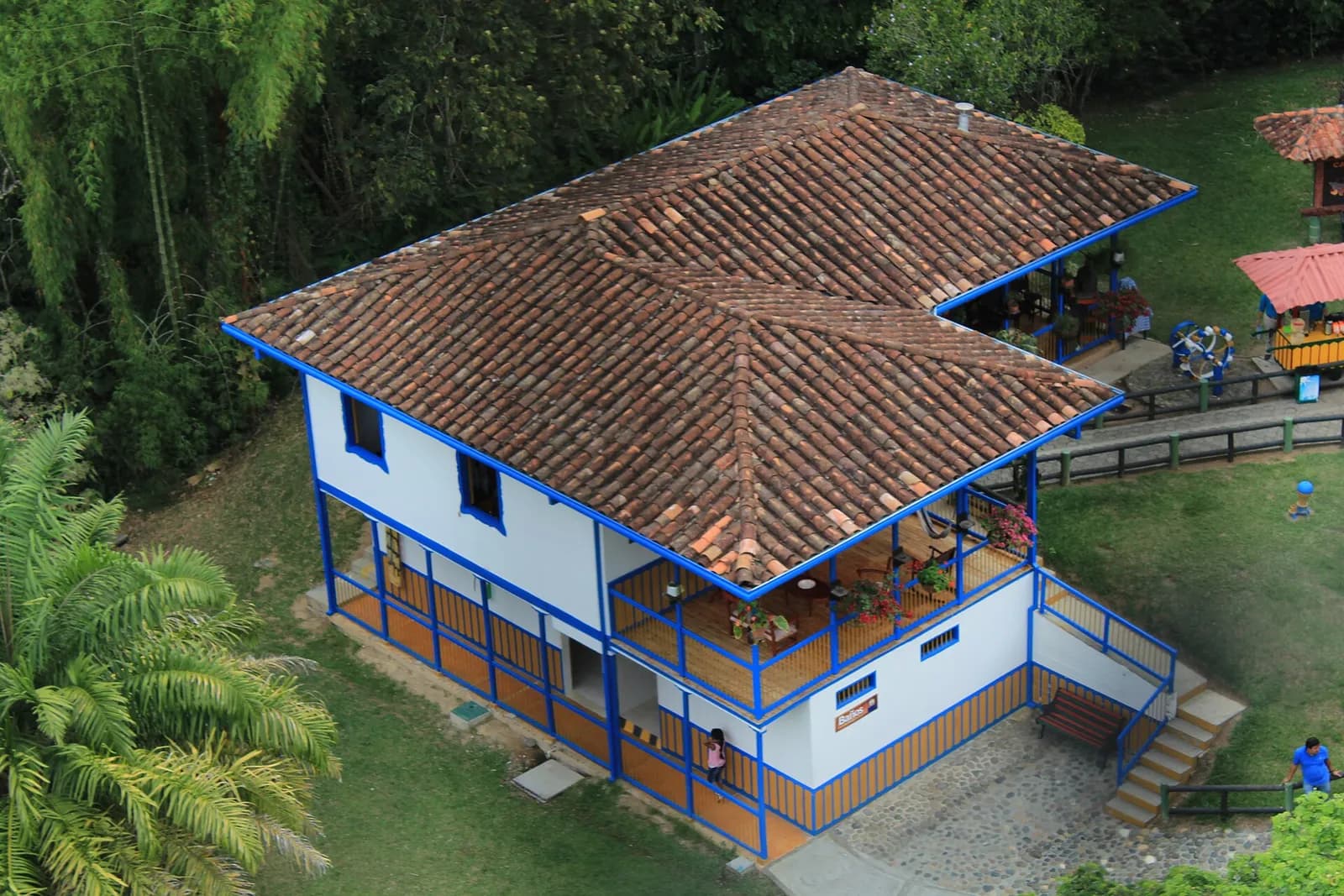 Casa de finca cafetera con techo de teja, vista desde arriba entre guaduales